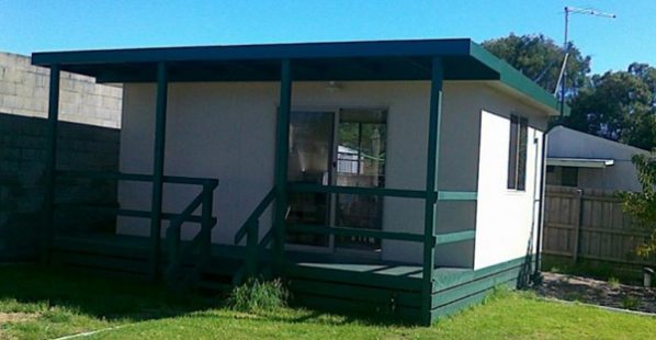 single room sleepout or bungalow with green verandah and white walls
